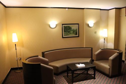 a living room with two chairs and a couch and a table at GSS Palace Hotel in Dubai