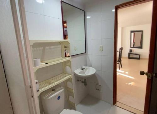a bathroom with a sink and a toilet and a mirror at RH06 Riohacha apto con vista mar 7 piso 4 personas in Ríohacha
