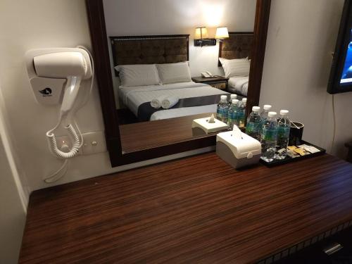a hotel room with a mirror and a phone on a table at Go Lodge Hotel Kuantan in Kuantan