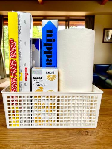 a basket filled with toilet paper and books on a table at Private Villa ietona in Fujikawaguchiko