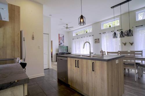 a kitchen with a sink and a counter top at Chalet L'Écureuil (waterfront, modern, spa, BBQ) in Chertsey