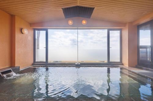 an indoor pool with a view of the ocean at Sado Resort Hotel Azuma in Sado