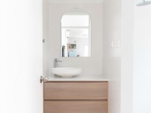 a bathroom with a sink and a mirror at No 6 ShoalHaven in Shoal Bay