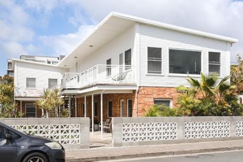 a white house with a white fence in front of it at No 6 ShoalHaven in Shoal Bay