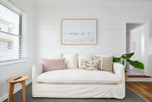a white couch in a living room with a picture on the wall at No 7 ShoalHaven in Shoal Bay