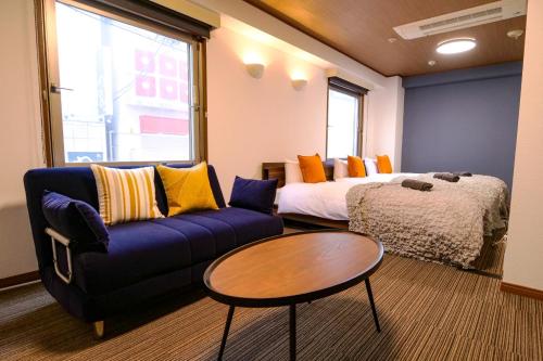 une pièce avec un canapé, un lit et une table dans l'établissement J-Court Oshiage, à Tokyo
