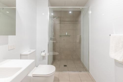 a white bathroom with a shower and a toilet at The Aire in Newcastle
