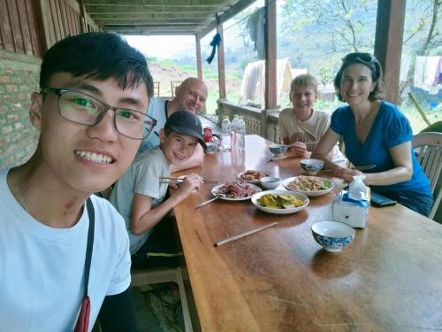 Un groupe de personnes assises autour d'une table et mangeant de la nourriture dans l'établissement Sapa Shalom Homestay, à Sa Pa