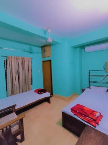 a room with two beds and a blue ceiling at Ayush Villa in Sirājganj