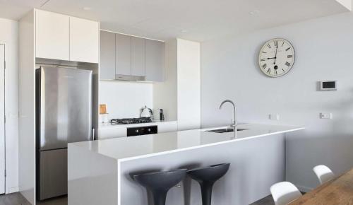 una cucina bianca con bancone e orologio sul muro di The Landing a Newcastle