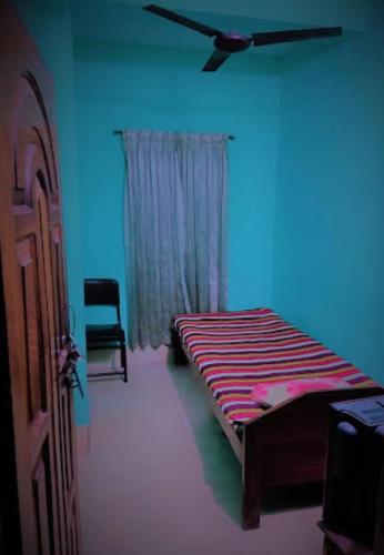 Cette chambre bleue comprend un lit et une chaise. dans l'établissement Ayush Villa, à Sirājganj