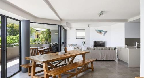 a kitchen and living room with a wooden table at The Drift in Nelson Bay