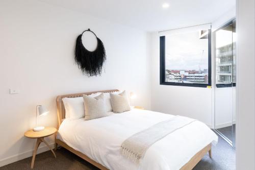 una camera da letto con un letto bianco e uno specchio a parete di The Edge a Newcastle