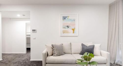 una sala de estar blanca con sofá y una pintura en The Muse - 1 bed option, en Newcastle