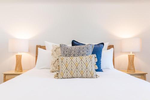 a bedroom with a white bed with pillows and two lamps at The Hideaway in Newcastle