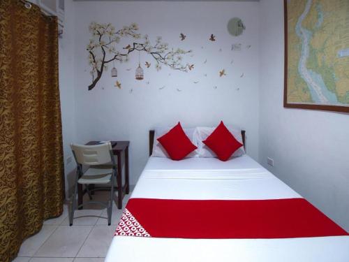 YOO Darius' Residences في موالبوال: غرفة نوم بسرير ومخدات حمراء وطاولة