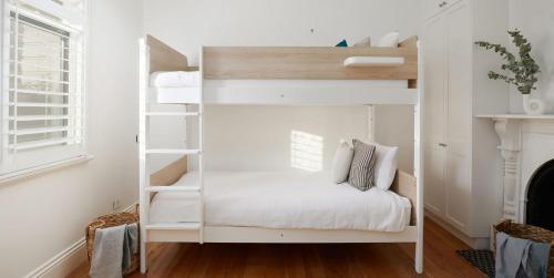 a white bunk bed in a room with a fireplace at The Willows in Wickham