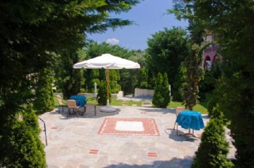 a patio with a table and an umbrella and chairs at Gi Ga Mar in Kriopigi