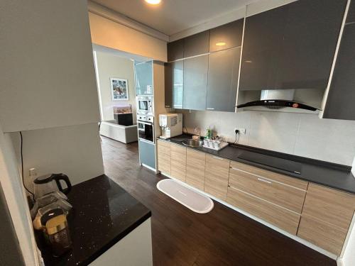 a kitchen with brown cabinets and a black counter top at INAP DESA EVO BANGI in Bandar Baru Bangi