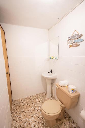a bathroom with a toilet and a sink at Vieques Tropical Guest House in Vieques