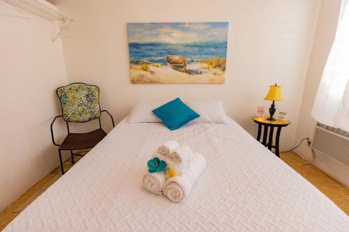 a bedroom with a bed with towels on it at Vieques Tropical Guest House in Vieques