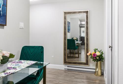 a mirror in a room with a table and a vase of flowers at One bedroom apartment Moncton North ! in Moncton