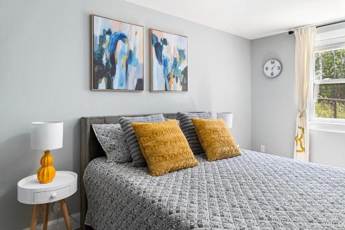 a bedroom with a bed with yellow pillows at One bedroom apartment Moncton North ! in Moncton