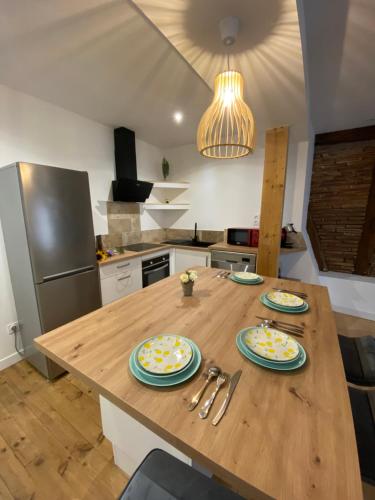 une cuisine avec une table en bois et des plaques de cuisson. dans l'établissement Logement tout équipé, à Layrac