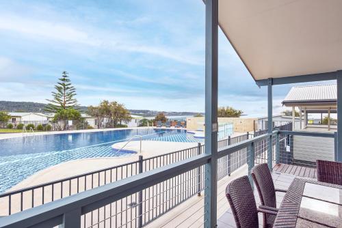 uma varanda com cadeiras e uma piscina em NRMA Merimbula Beach Holiday Resort em Merimbula