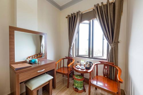 Habitación con escritorio, espejo y ventana. en Hon Dau Resort, en Do Son