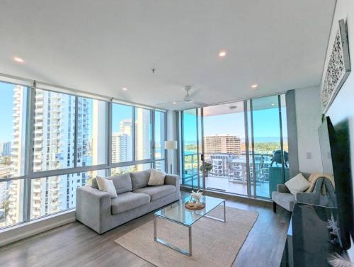 uma sala de estar com um sofá e uma mesa em Modern Gold Coast Apartment with great Amenities em Gold Coast