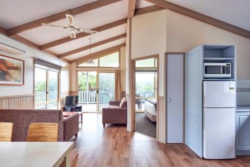 a living room with a kitchen and a living room with a refrigerator at NRMA Merimbula Beach Holiday Resort in Merimbula