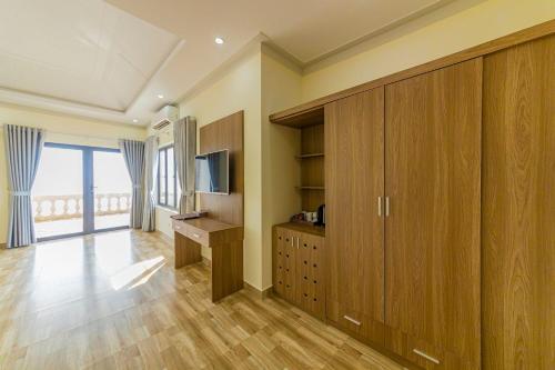 a living room with wooden cabinets and a television at Hon Dau Resort in Ðố Sơn