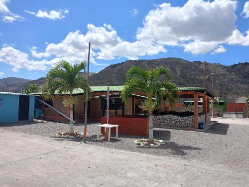 a building with two palm trees in front of it at Villas Norita in Ibarra