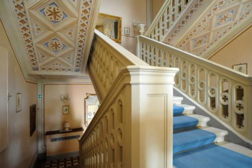a staircase in a home with blue carpet at Relais Castelluccio Palusse in Città della Pieve
