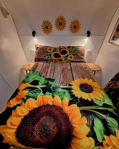 a bedroom with a bed with sunflowers on it at Rose City Caravan Park in Warwick