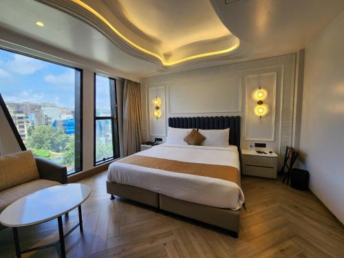 una camera d'albergo con un grande letto e un divano di Dragonfly Hotel- The Art Hotel a Mumbai