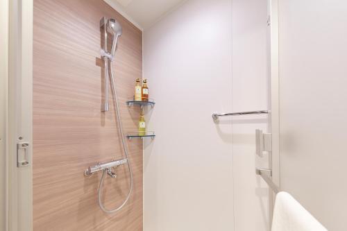 a bathroom with a shower with a shower head at hotel MONday KYOTO MARUTAMACHI in Kyoto