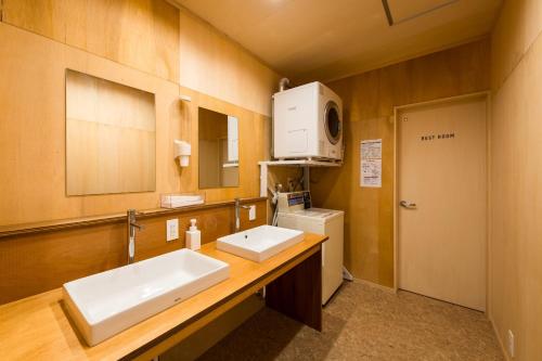 a bathroom with two sinks and a microwave at 三津ミーツ in Mitsuhama