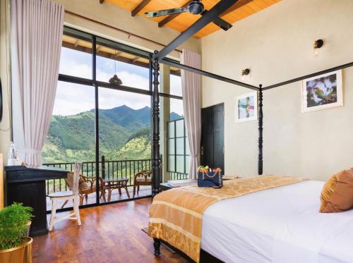 a bedroom with a bed and a balcony with mountains at The Capoe House in Haputale