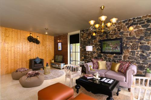 a living room with a stone wall at The Capoe House in Haputale