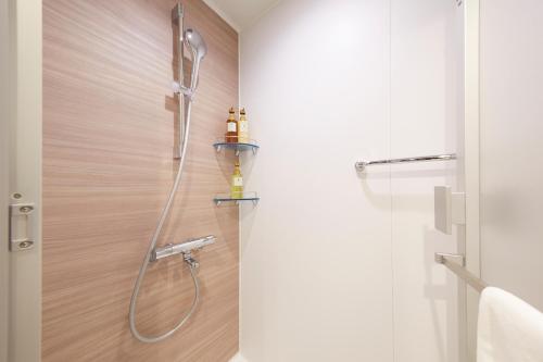 a shower with a shower head in a bathroom at hotel MONday KYOTO MARUTAMACHI in Kyoto