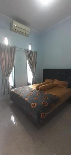 TalangbetutuにあるVILLA INTAN PALEMBANGの窓付きの部屋にベッド付きのベッドルーム1室があります。