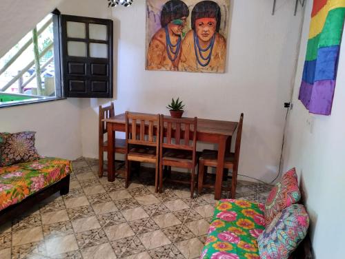 a dining room with a table and a couch at Jurema Hostel in Itacaré