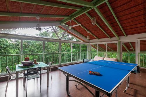 a screened in porch with a ping pong table at StayVista at Vanya Farms - Orchard Villa with Rustic Vintage interiors & Table Tennis table in Alibag