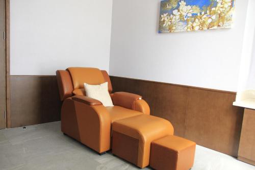 a waiting room with a chair and stool at The Art Nest Hotel Nha Trang in Nha Trang
