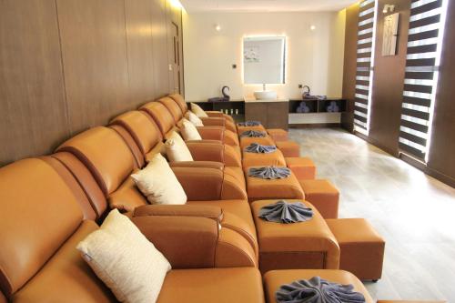 a row of brown leather couches in a room at The Art Nest Hotel Nha Trang in Nha Trang