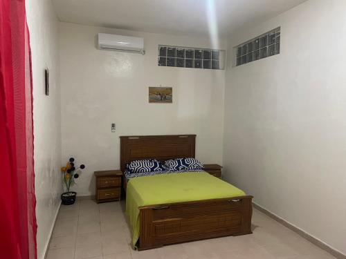 ein Schlafzimmer mit einem Bett mit einer grünen Decke in der Unterkunft Chez papy 2 in Dakar