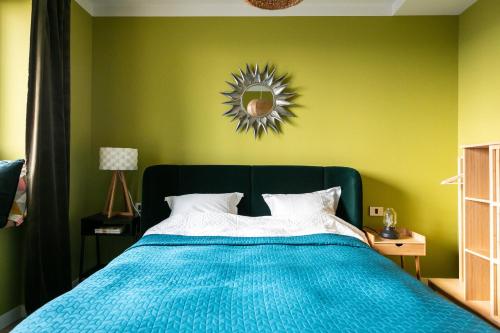 een slaapkamer met een blauw bed en een groene muur bij Leaf Apartment - Aviatiei Home in Boekarest