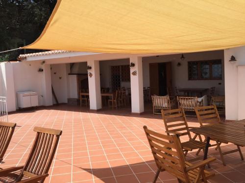 a patio with chairs and tables and a yellow tent at B&B Villa sul Mare in Melito di Porto Salvo